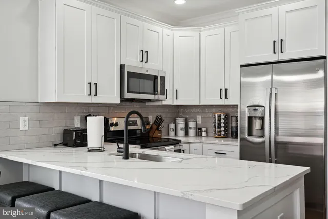 a kitchen with appliances a sink and cabinets