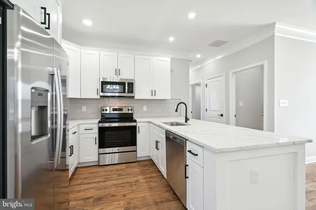 a kitchen with stainless steel appliances granite countertop a refrigerator and a stove top oven