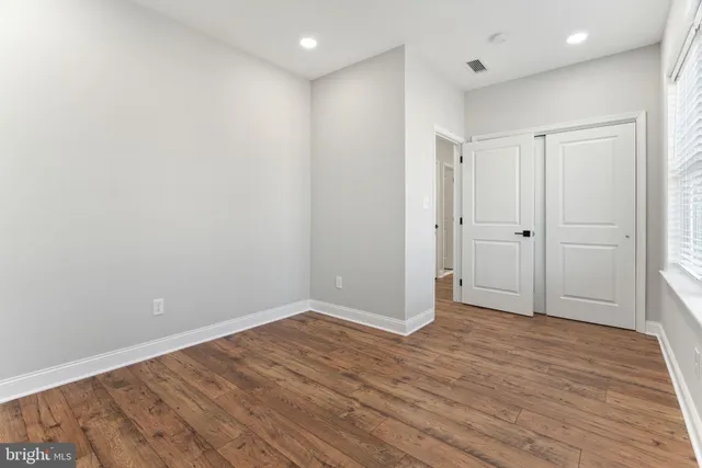 a view of an empty room with wooden floor