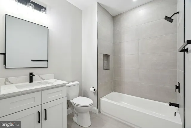 a bathroom with a toilet a sink a mirror and bathtub