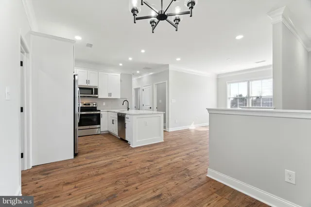 a view of kitchen with kitchen island wooden floor center island and appliances