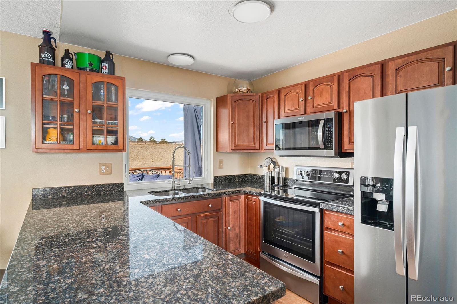 10351 Routt Street Broomfield, CO 80021 - Photo 11 of 31 a kitchen with stainless steel appliances granite countertop a stove sink and microwave