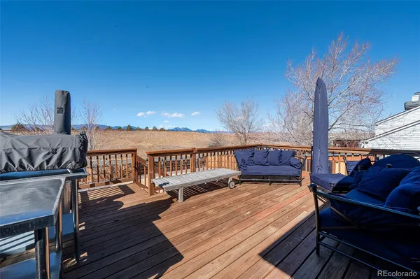 a view of a balcony with chairs and wooden floor