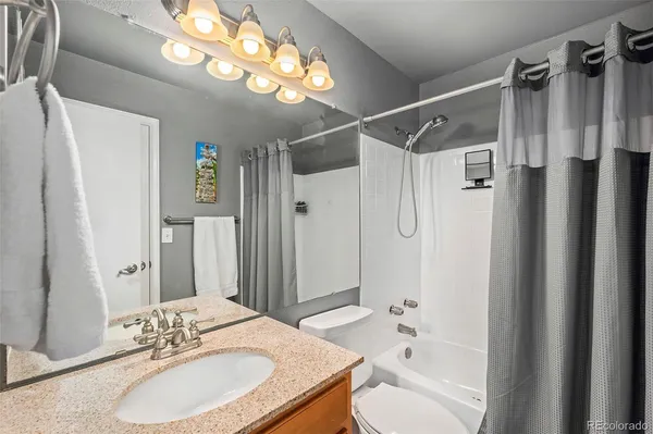 a bathroom with a granite countertop sink toilet and shower