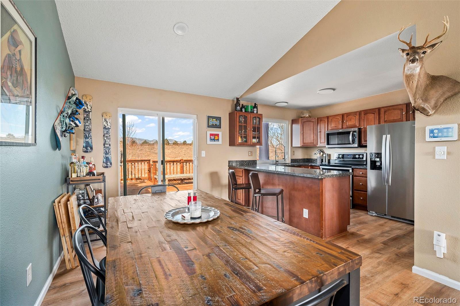 10351 Routt Street Broomfield, CO 80021 - Photo 8 of 31 a open dining room with stainless steel appliances granite countertop a couch dining table and chairs with wooden floor