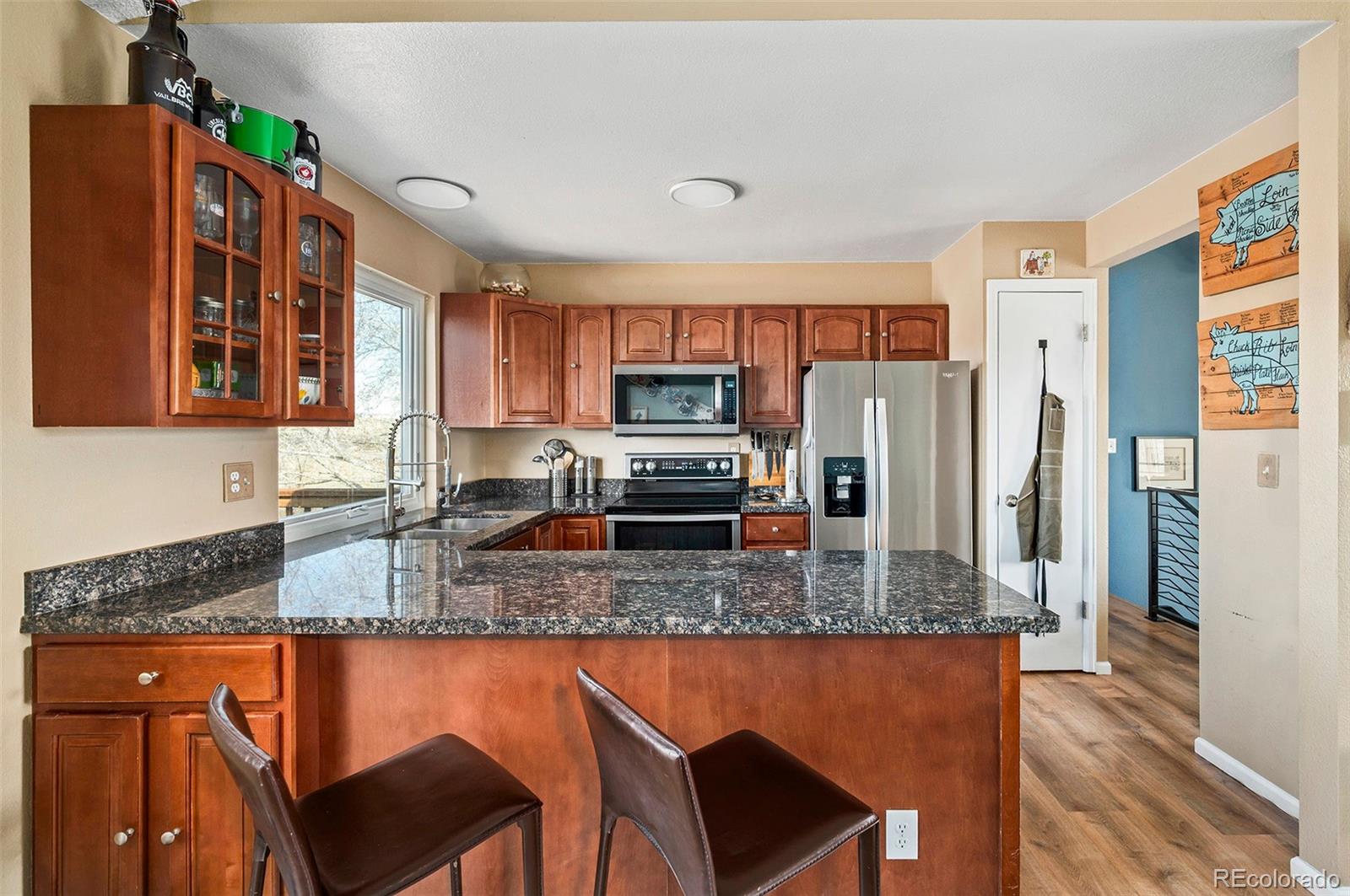 10351 Routt Street Broomfield, CO 80021 - Photo 10 of 31 a kitchen with stainless steel appliances granite countertop a stove top oven a refrigerator a sink and a granite counter tops