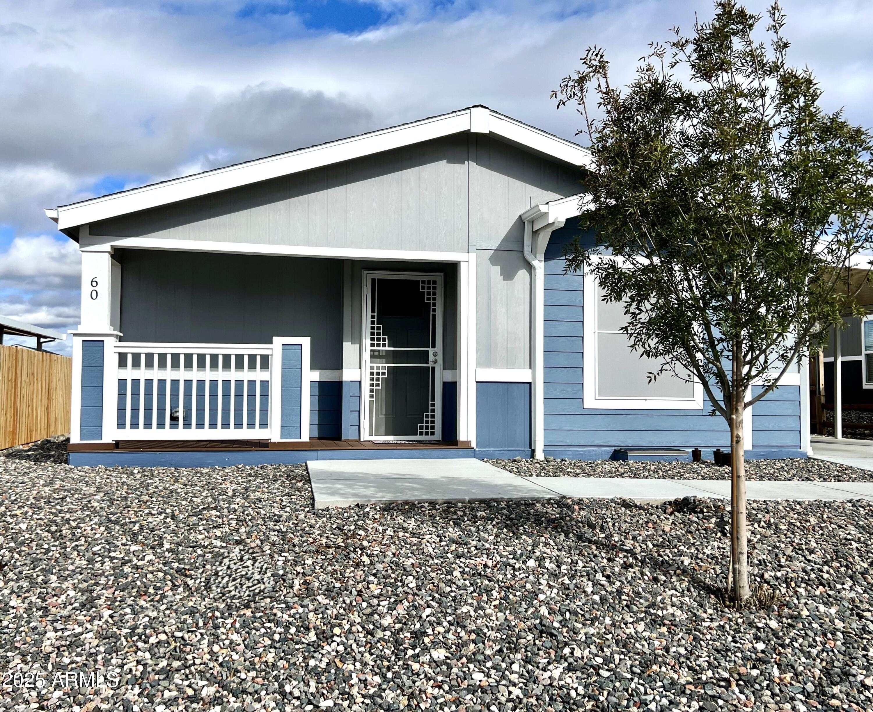 a view of a house with a small yard and a large window with wooden fence