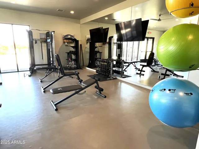 a living room with furniture a large window and wooden floor