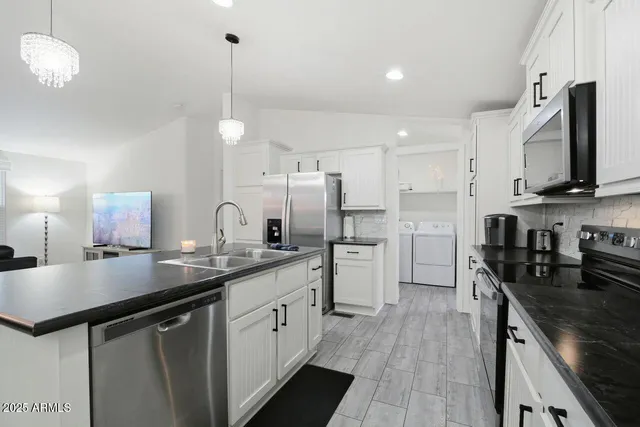 a kitchen with cabinets stainless steel appliances a sink and a stove