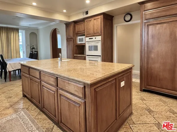 a kitchen with stainless steel appliances granite countertop a refrigerator and a stove