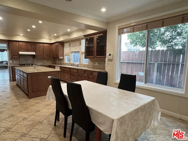 a kitchen with stainless steel appliances granite countertop a stove a table and chairs
