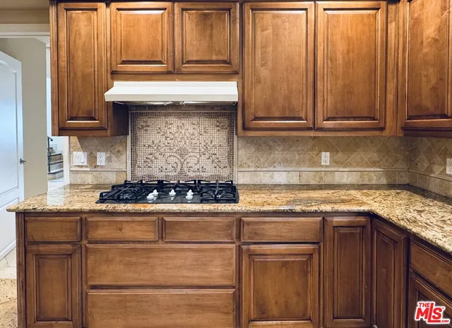 a kitchen with granite countertop cabinets and white stove