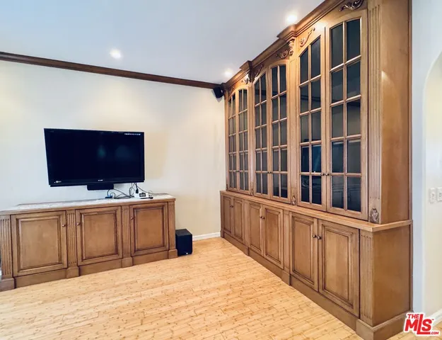 a view of an empty room with furniture and wooden floor