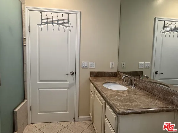 a bathroom with a granite countertop sink and a mirror