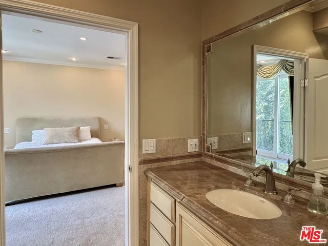 a bathroom with a granite countertop sink and a mirror