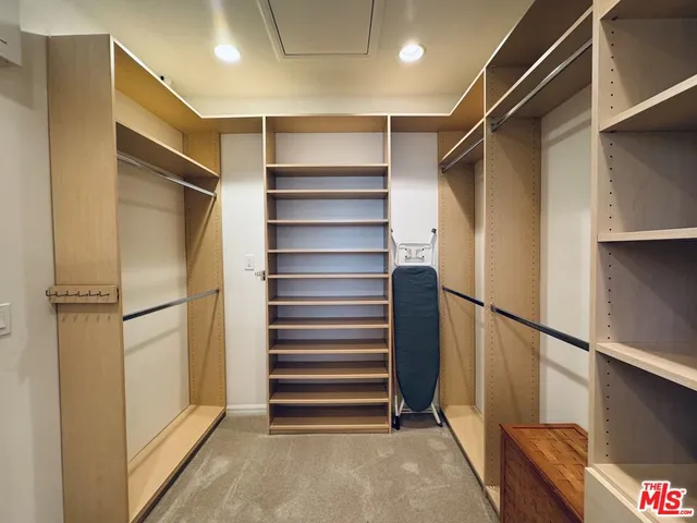 a view of walk in closet with empty racks