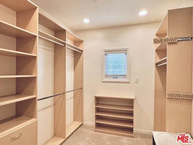 a view of walk in closet with empty racks