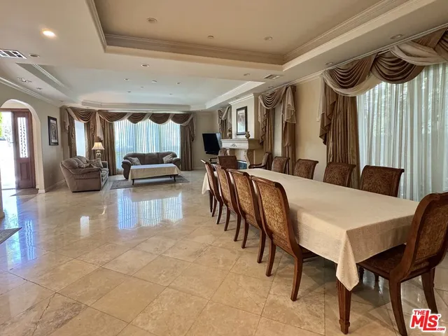 a dining hall with couches a dining table and chairs with wooden floor