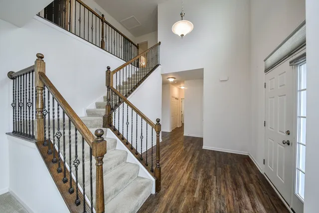 a view of staircase with wooden floor and white walls