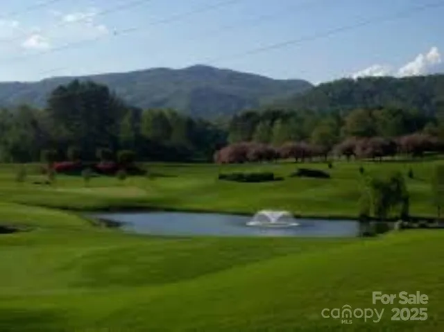 a view of a wooden house with a yard and sitting area