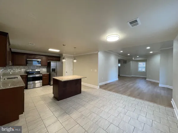 a view of kitchen with stainless steel appliances cabinets