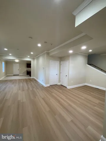 a view of an empty room with wooden floor