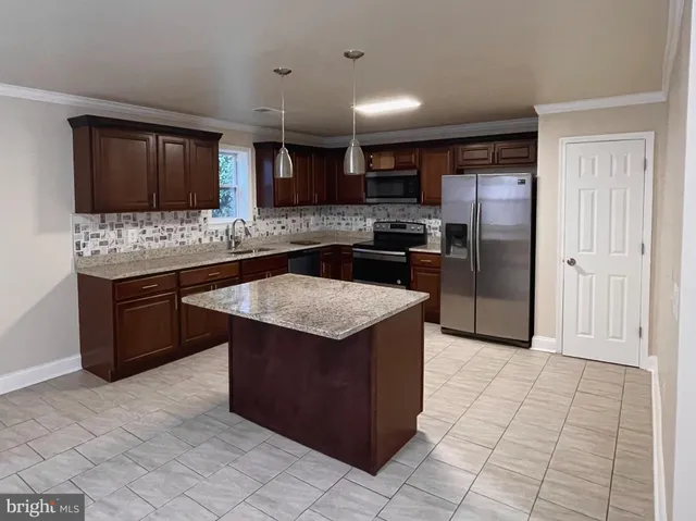 a kitchen with stainless steel appliances granite countertop a stove a refrigerator and a oven