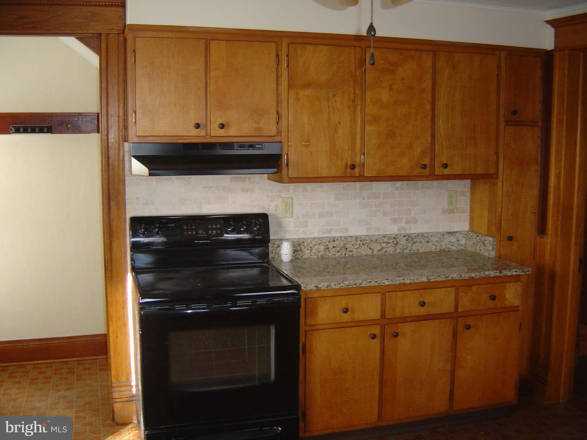305 Main Street New Windsor, MD 21776 - Photo 22 of 30 a kitchen with granite countertop cabinets and black appliances