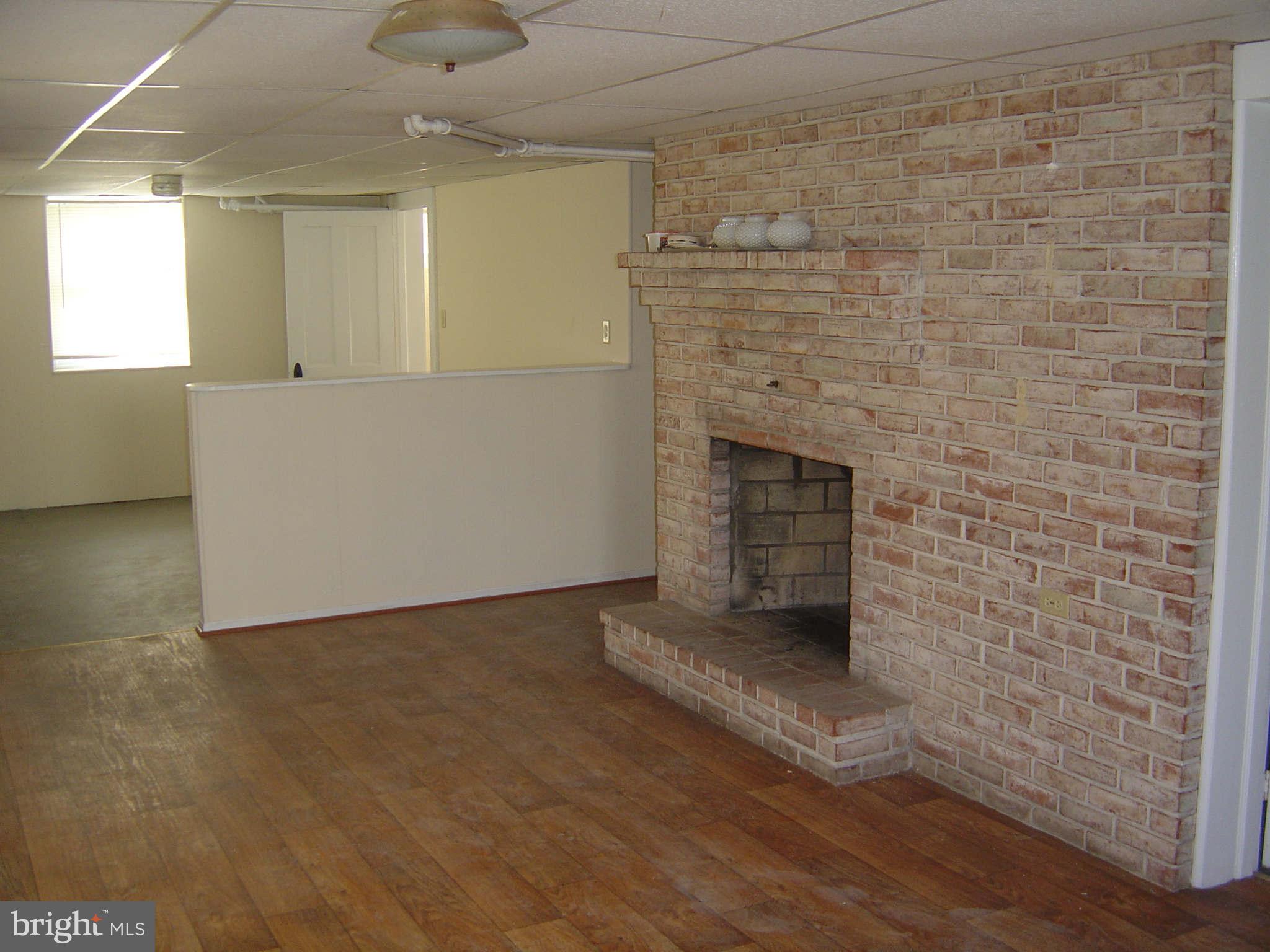 305 Main Street New Windsor, MD 21776 - Photo 24 of 30 a view of an empty room with a fireplace and a window