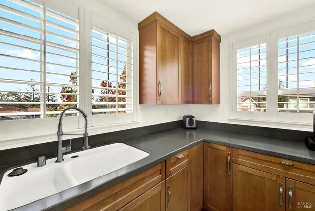 a white toilet sitting next to a bathroom sink and a mirror
