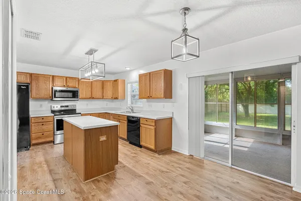 a kitchen with granite countertop a sink a counter top space appliances and cabinets