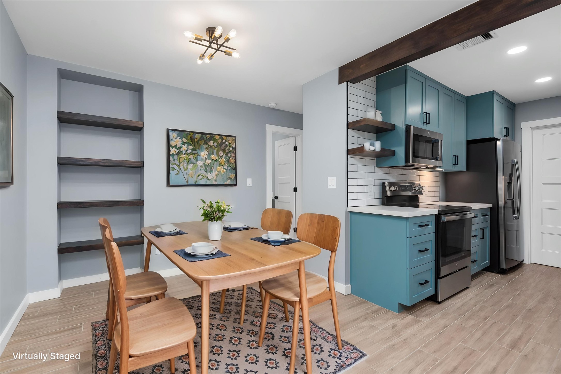Stunning open-concept kitchen and dining area — custom cabinetry, quartz countertops, and handcrafted floating shelves. Virtually staged.
