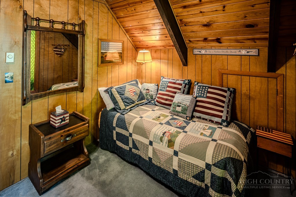 107-109 Shagbark Road Beech Mountain, NC 28604 - Photo 37 of 45 a bedroom with a bed and a mirror