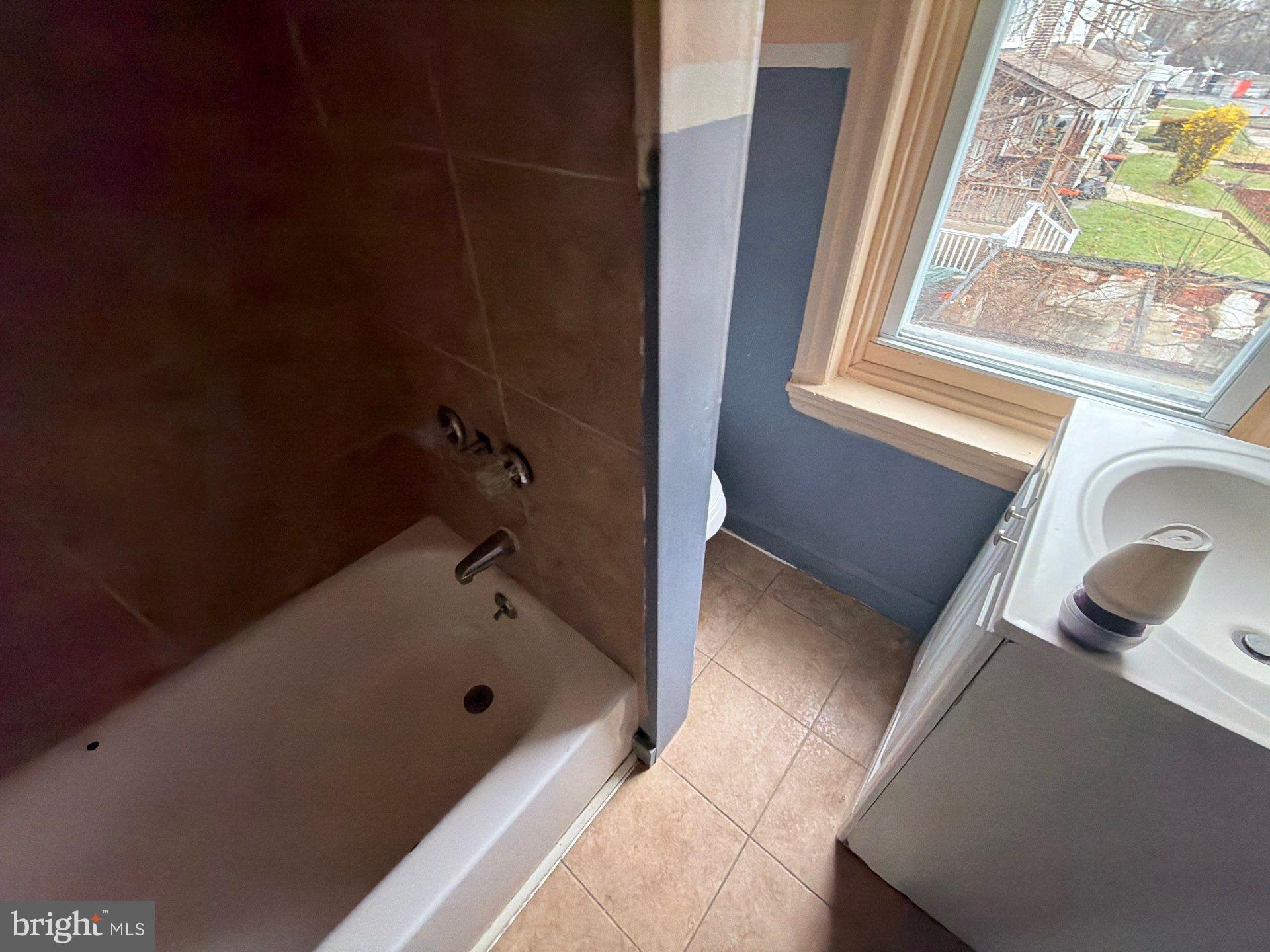 800 West 11th Street Chester, PA 19013 - Photo 11 of 17 a bathroom with a tub sink and mirror