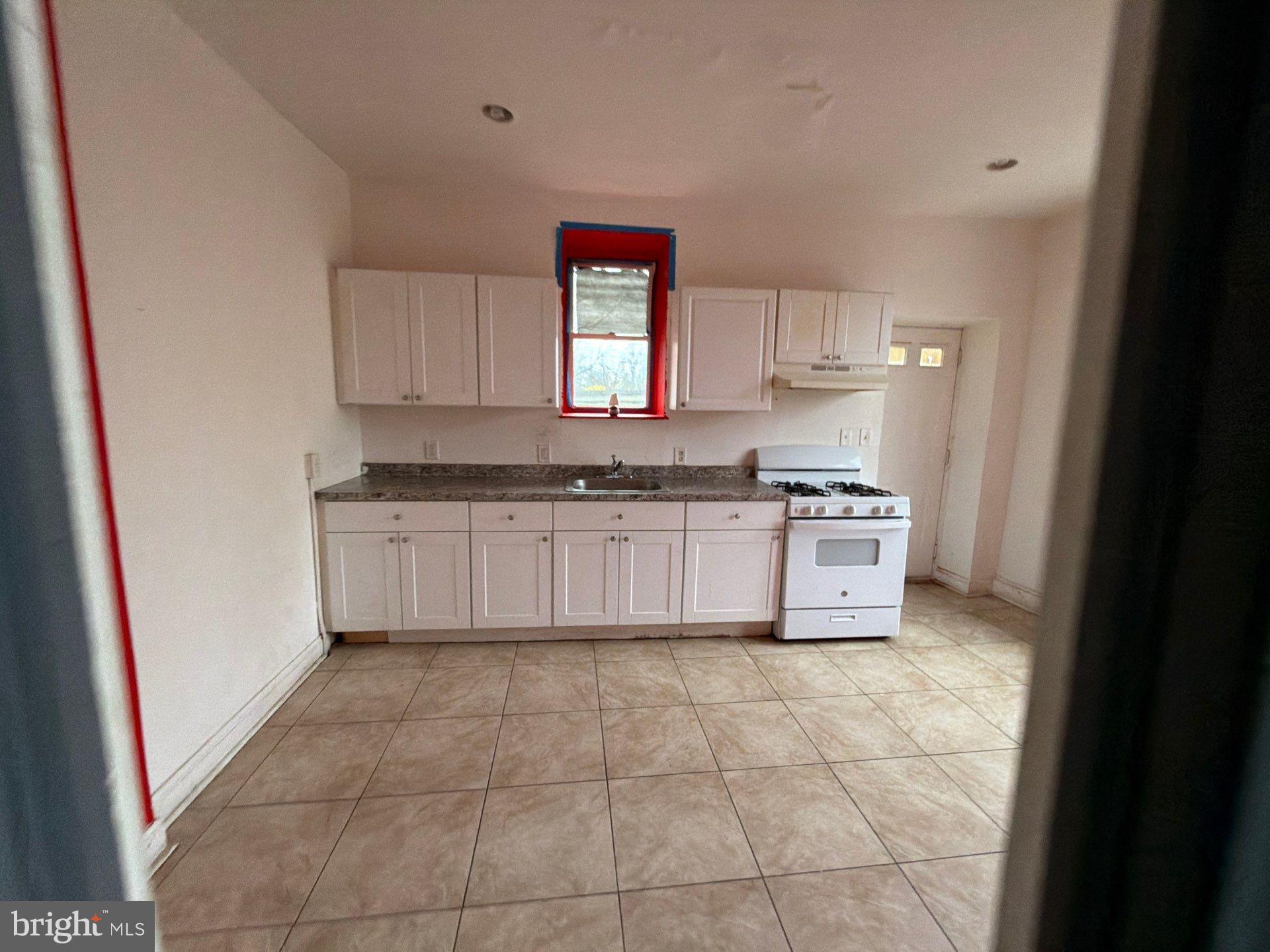 800 West 11th Street Chester, PA 19013 - Photo 3 of 17 a kitchen with a stove a sink and a refrigerator