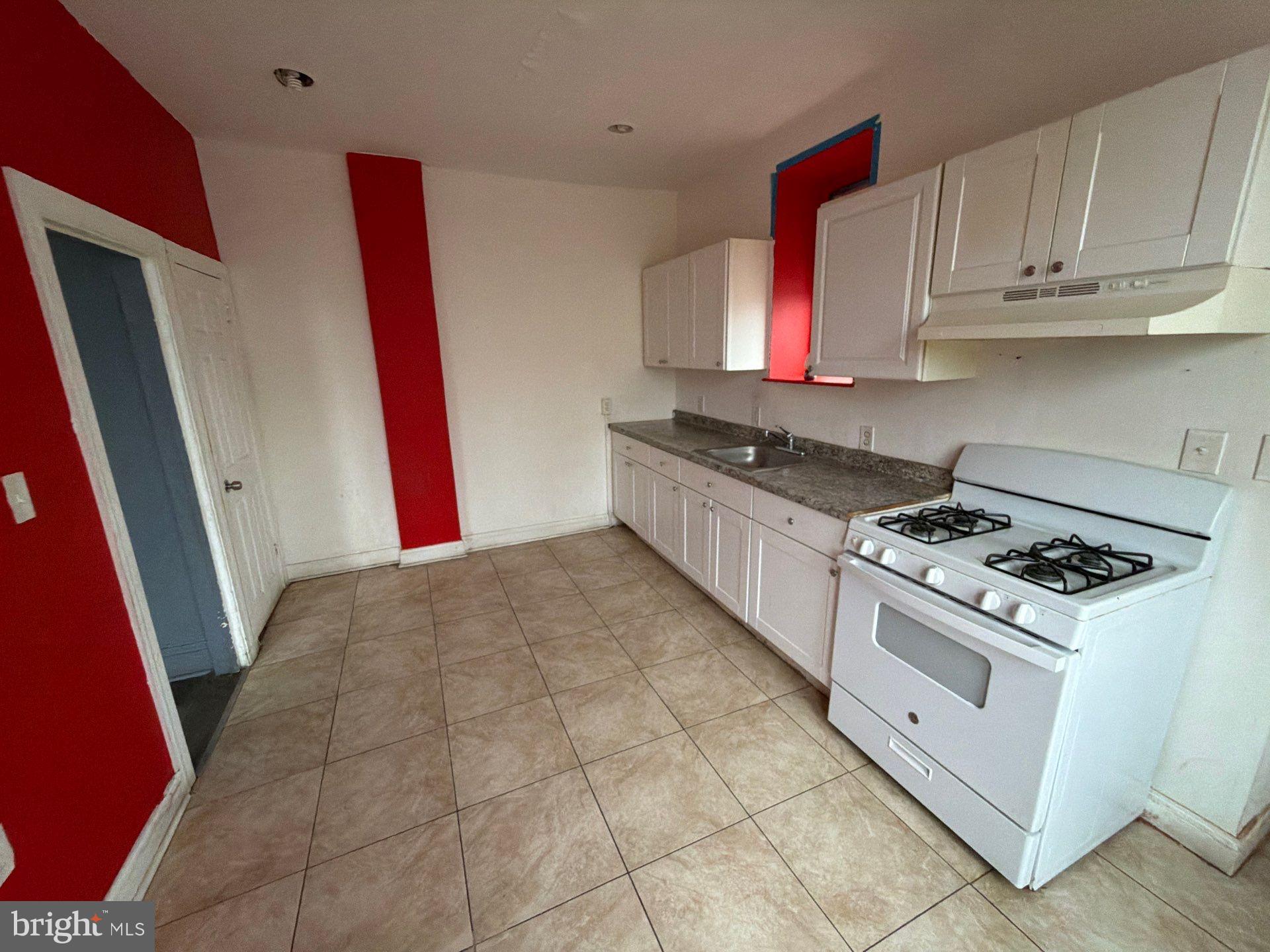 800 West 11th Street Chester, PA 19013 - Photo 5 of 17 a kitchen with stainless steel appliances granite countertop a stove a sink and a microwave