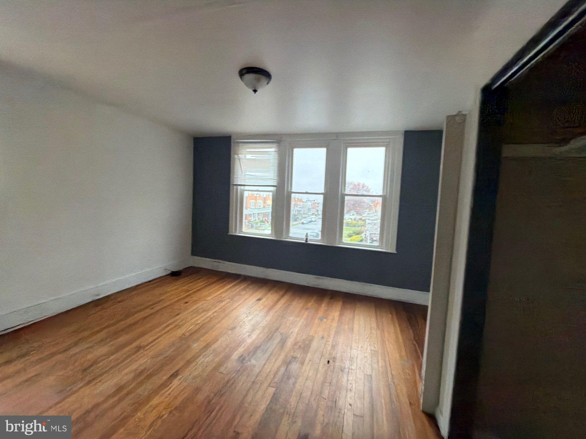 800 West 11th Street Chester, PA 19013 - Photo 7 of 17 a view of an empty room with wooden floor and a window