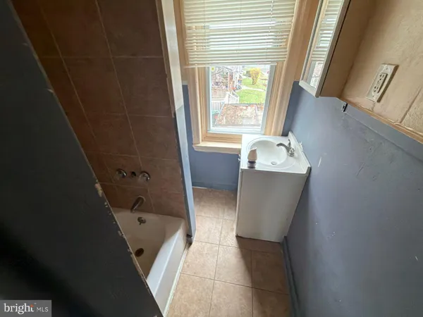 a bathroom with a bathtub sink and mirror