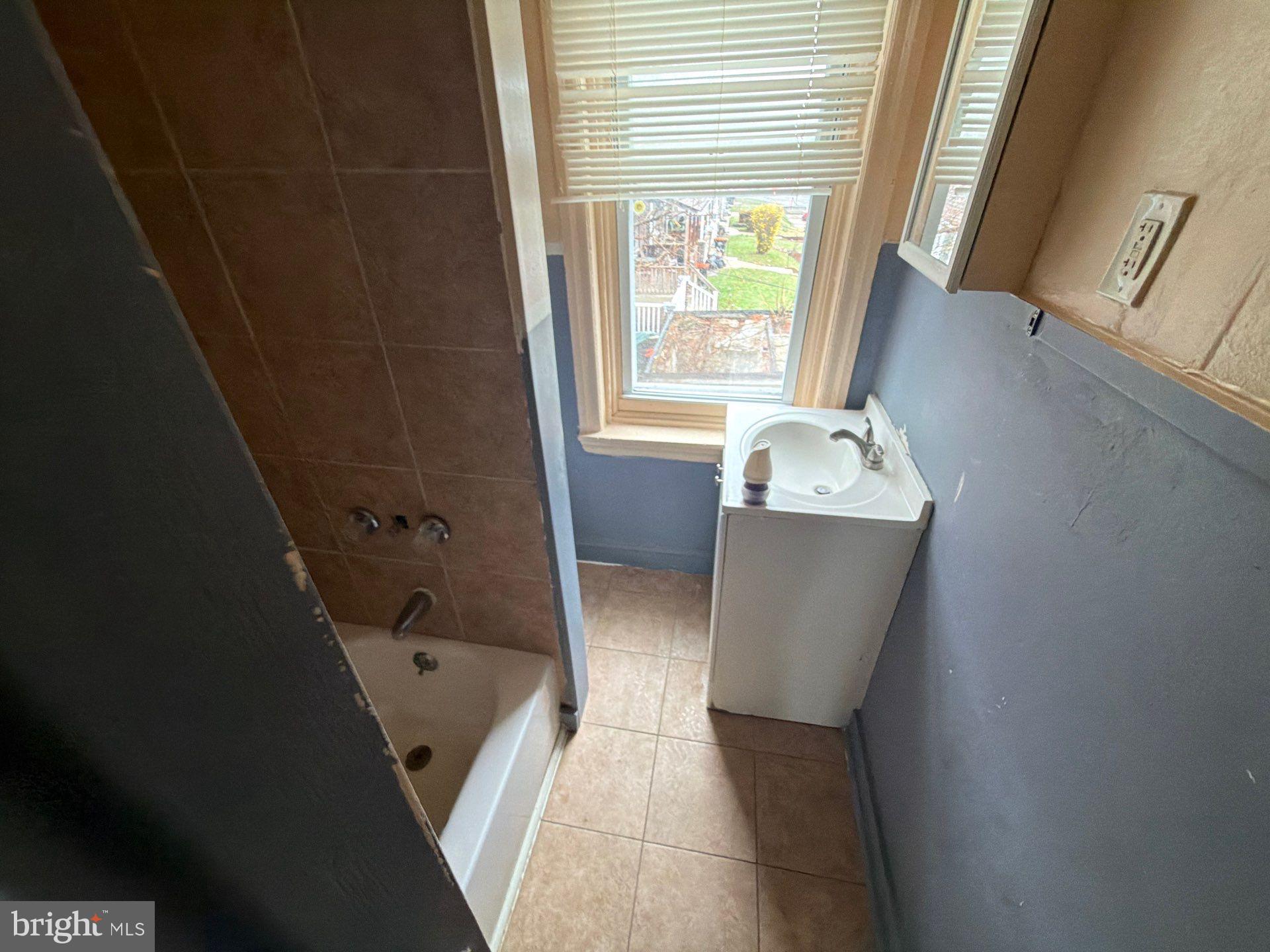 800 West 11th Street Chester, PA 19013 - Photo 9 of 17 a bathroom with a bathtub sink and mirror
