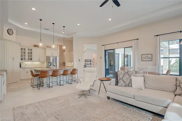 a kitchen with stainless steel appliances kitchen island granite countertop a sink a stove a dining table and chairs