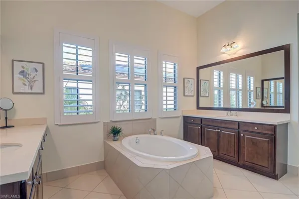 a spacious bathroom with a granite countertop tub sink and mirror