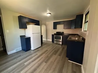 a kitchen with a refrigerator and a stove top oven