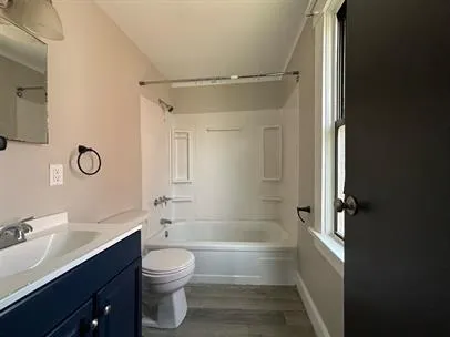 a bathroom with a bathtub shower sink vanity and toilet