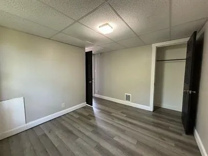 an empty room with wooden floor and closet