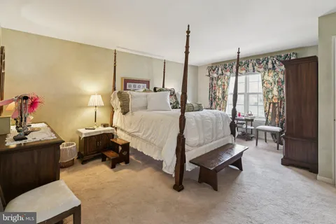 a bedroom with a bed window and a flat screen tv