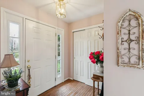 a kitchen with stainless steel appliances white cabinets sink and wooden floor