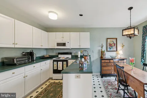 a kitchen with granite countertop a sink a stove and cabinets