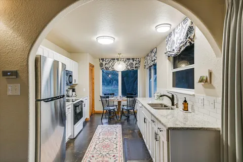 a kitchen with sink stove top oven and cabinets