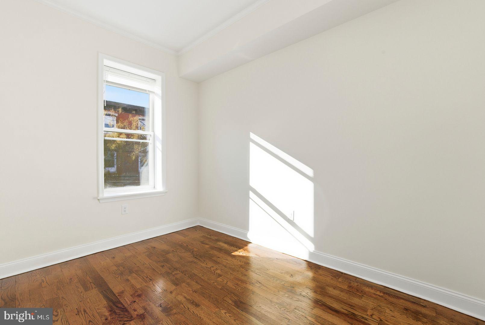 1723-0 Master Street, Unit D Philadelphia, PA 19121 - Photo 11 of 23 an empty room with wooden floor and windows