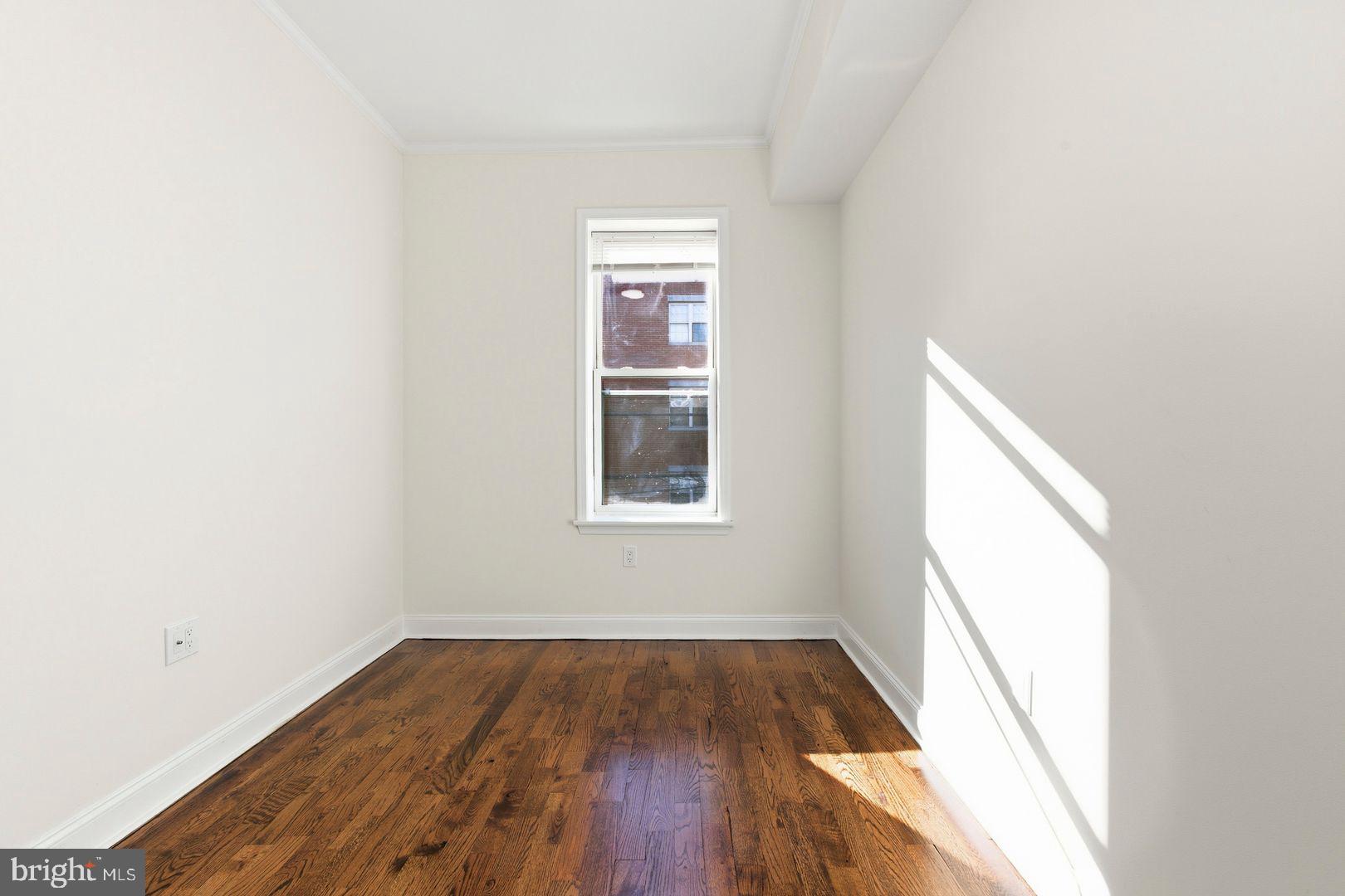 1723-0 Master Street, Unit D Philadelphia, PA 19121 - Photo 12 of 23 an empty room with wooden floor and windows